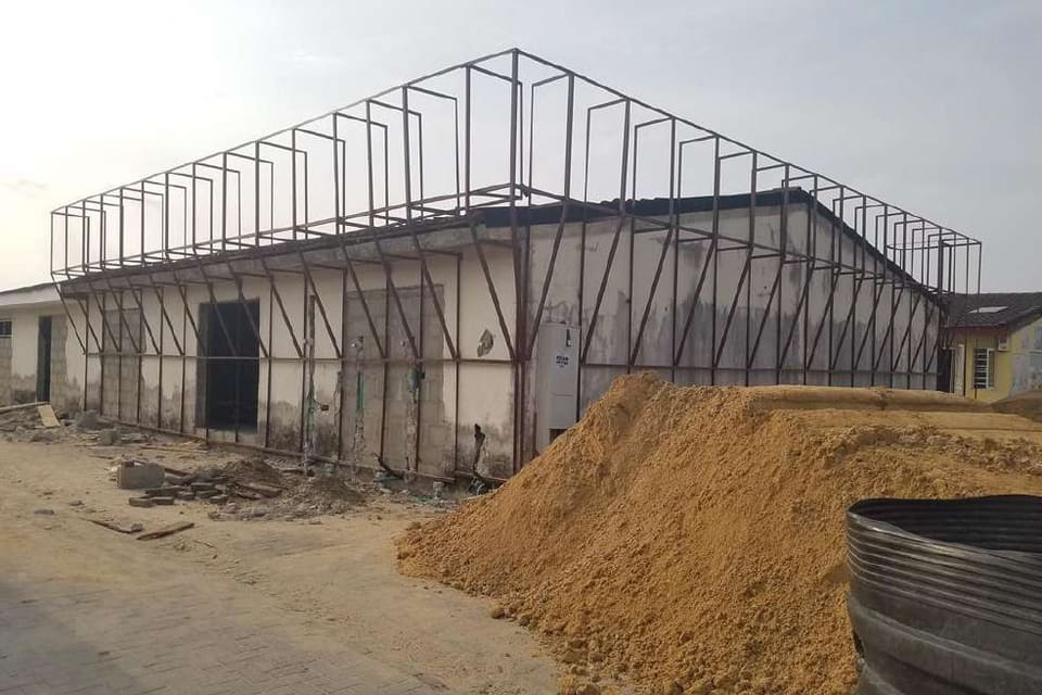 Steel framing rising above the branch walls — HFP Shopping Complex, Lagos