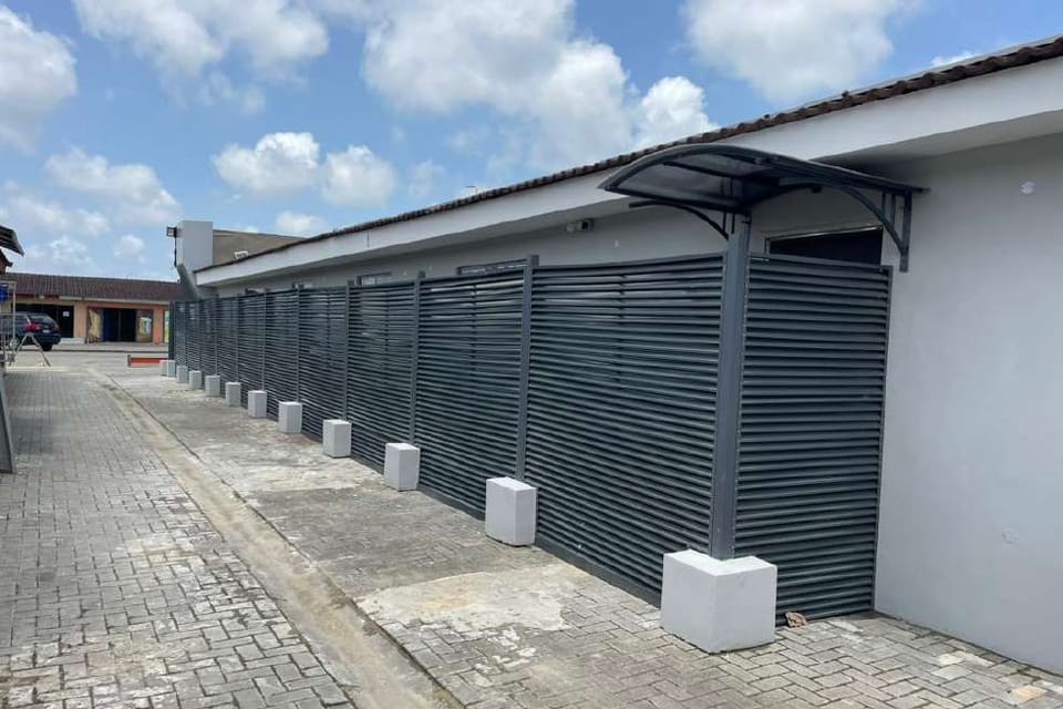 Dark louvred boundary fence beside interlocking paving — HFP Shopping Complex, Lagos